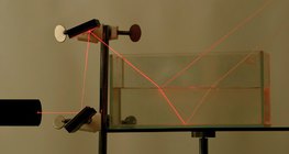 Refraction and reflection of laser light at the boundaries of air and water and water and glass